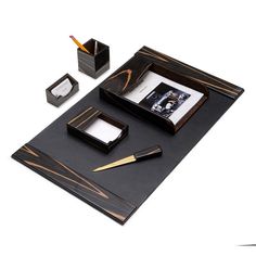 a black desk set with pen, notebook and inkwell on it's side