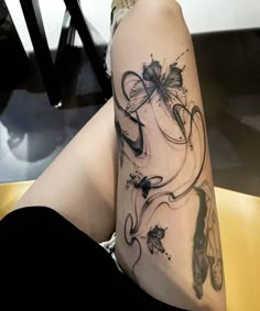 a woman's legs with tattoos on them and butterflies in the middle of her leg