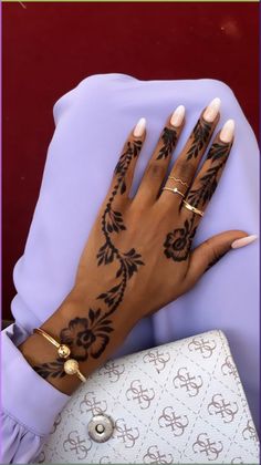 a woman's hand with henna tattoos on it