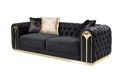 a black and gold couch with two pillows on the armrests, in front of a white background