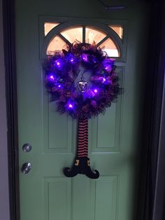 a wreath with purple lights on the front door