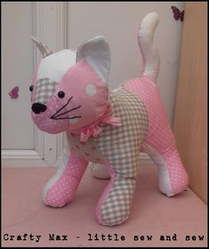 a pink and white cat stuffed animal next to a door