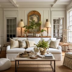 a living room filled with white furniture and lots of plants on top of a coffee table