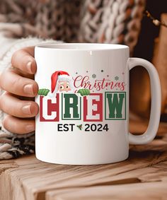 a person holding a white coffee mug with the words christmas crew est 2024 on it