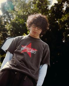 a young man sitting on top of a chair wearing a t - shirt with the word rock and roll written on it