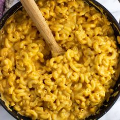 macaroni and cheese in a skillet with a wooden spoon on the side