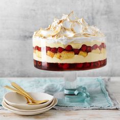 a trifle with strawberries and whipped cream on top is sitting on a table