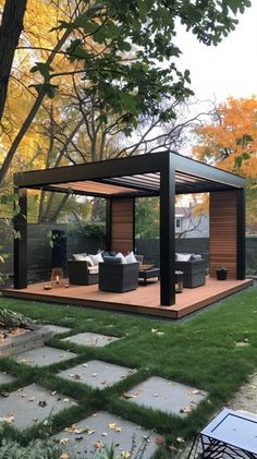 an outdoor living area in the middle of a yard with grass and trees around it