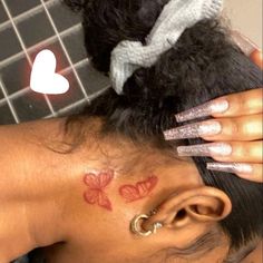 a woman with butterfly tattoos on her neck and behind her head is a teddy bear