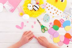 someone is making paper crafts with scissors and other crafting supplies on a white table