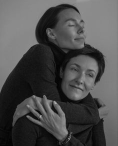 two women hugging each other in black and white