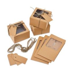 four boxes with tags attached to them sitting on top of each other and tied in twine