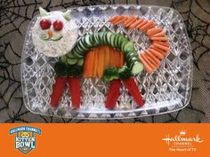 a plastic tray with carrots, cucumbers and other food items on it