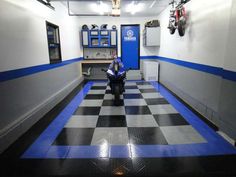 a man sitting on a checkered floor in a garage