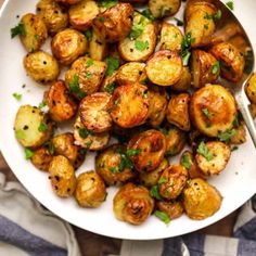 a white bowl filled with cooked potatoes and garnished with parsley