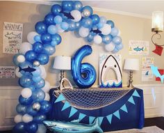 the balloon arch is decorated with blue and white balloons that spell out the number six