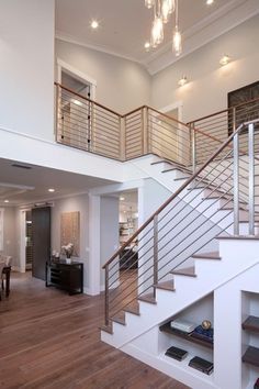 a living room filled with lots of furniture and a staircase leading up to the second floor