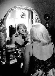 a woman is looking at herself in the mirror