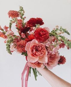 a bouquet of flowers is being held by someone's hand