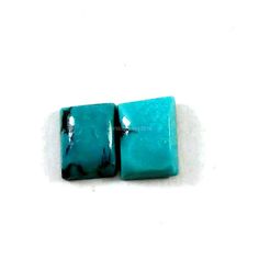 two square turquoise colored beads on white background