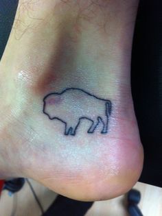 a small tattoo on the foot of a person's foot with an animal drawn on it