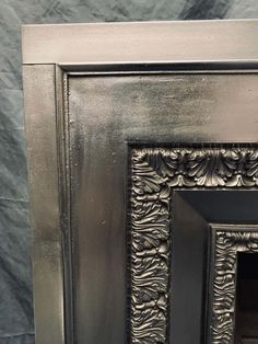 an ornate metal fireplace surround with black paint