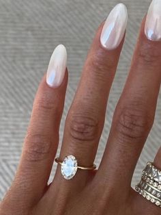 a woman's hand with two rings and a ring on her finger, one is white