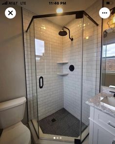 a bathroom with a walk in shower next to a toilet