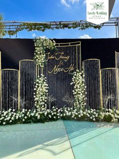 the entrance to an event with white flowers and greenery on it's sides