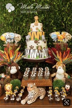 an animal themed birthday party with cake, cupcakes and jungle animals on the table