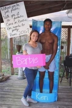 a man and woman standing next to each other in front of a sign that says barbie on it