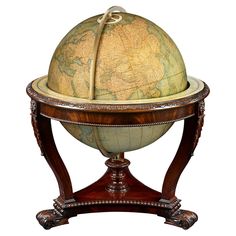 an old world globe sitting on top of a wooden stand