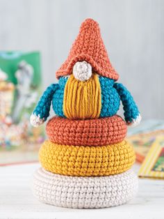 a stack of crocheted hats sitting on top of each other in different colors