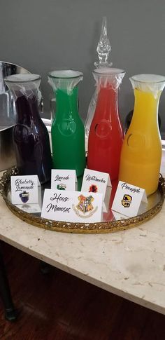 a tray that has some drinks on it and cards in front of the bottles with name tags