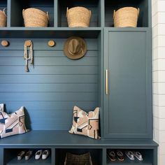 a blue bench with baskets and hats on it's back, next to some shoes