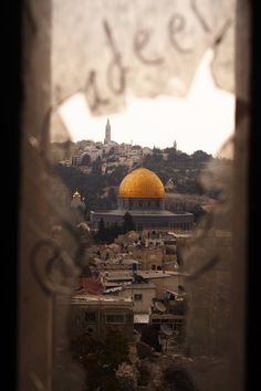 the dome of the rock as seen through a window with a view of city below