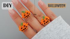 someone is holding their hand with orange beads on it