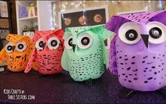 four colorful owls sitting on top of a table