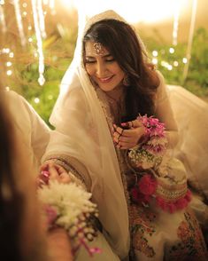 a woman in a wedding outfit holding flowers