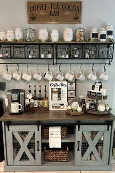 a coffee bar with lots of cups and mugs on the shelves above it,