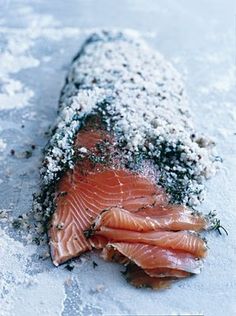 a piece of salmon covered in seasoning on top of snow