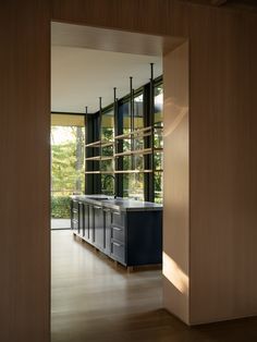 an open kitchen with wooden walls and flooring next to a sliding glass door that leads outside