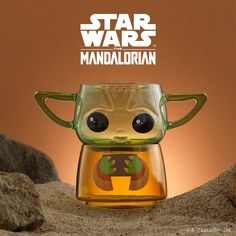 a star wars figurine in a glass cup with an image of baby yoda on it