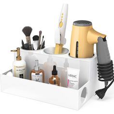 The Fallon Hair Tool and Accessory Organization Station features 3 openings for storing your hair tools: hair dryers, curling irons, flat irons, and straighteners. The lower tier features a large storage bin to hold all your hair products, brushes, lotions, and other accessories. The lower tier is also pre-cut with side openings allowing you to insert your own power surge strip to make an easy-to-access power station right where you need it. The top storage bins include stainless steel cups which are also great for storing brushes, pencils, tall cosmetics, and more. The unit measures 11.8" wide x 7.3" deep x 5.3" tall. Each stainless steel cup is 3.5" wide and 4.9" deep. Made of handmade, polished high-quality acrylic. Available in a variety of colors. Bathroom Countertop Storage, Blow Dryer Holder, Blow Dryers, Hair Tool Organizer, Counter Top Accessories, Acrylic Holders, Door Shoe Organizer, Hair Tool, Hair Dryer Holder