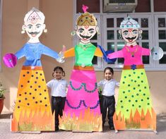 three children are standing in front of some paper puppets