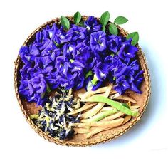 a basket filled with purple flowers on top of a white table