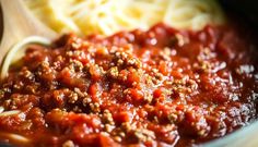 pasta and meat sauce in a pot with a wooden spoon on the side, ready to be eaten