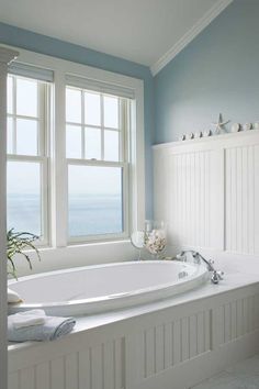 a large white bath tub sitting next to a window