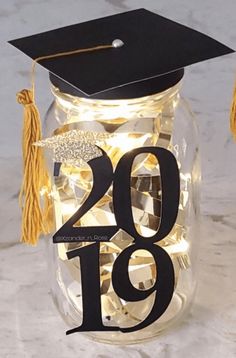 a graduation cap and tassel on top of a jar with the number 19 in it