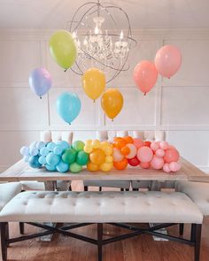 a table with balloons on it and a bench in front of the table for seating